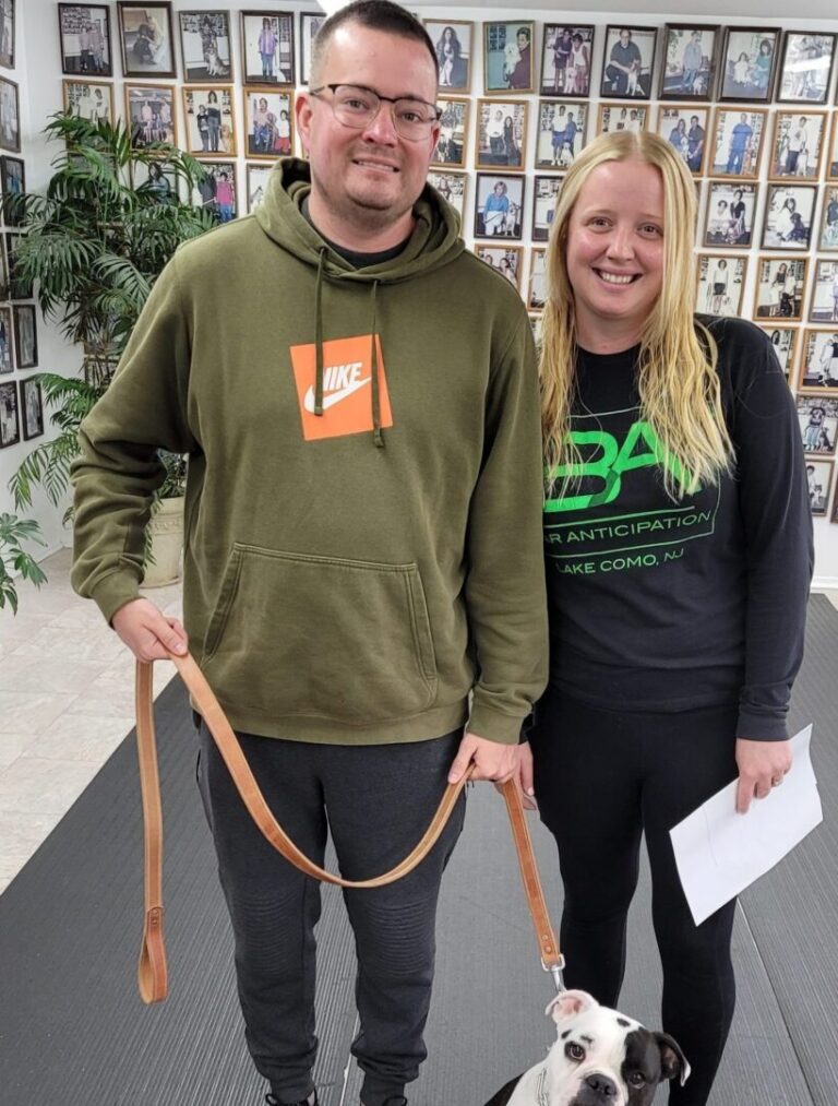 a man and a woman with a dog on a leash