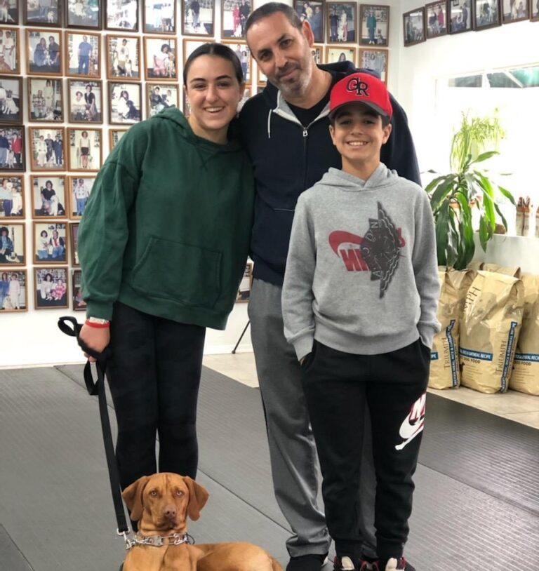 a man, woman and child standing with a dog