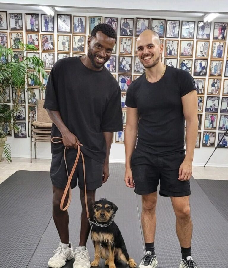 a couple of men standing next to a dog