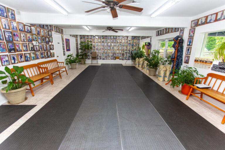 a room with a black floor and wooden benches