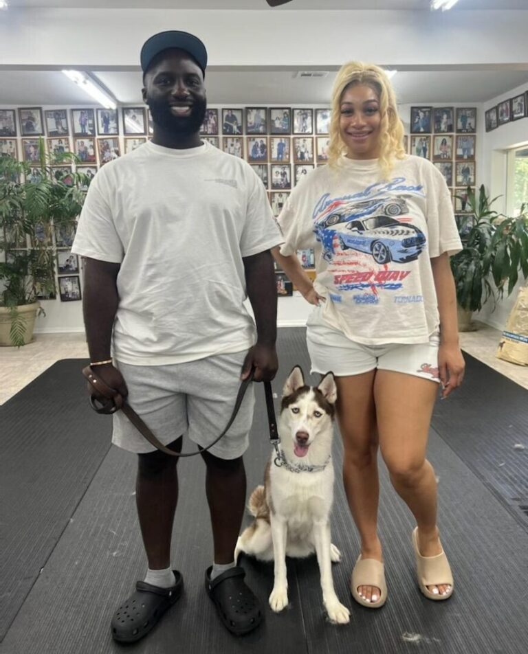 a man and a woman standing next to a dog