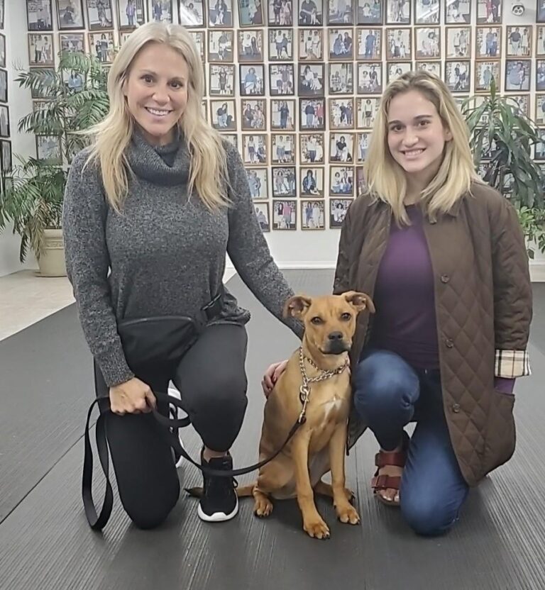 two women and a dog posing for a picture