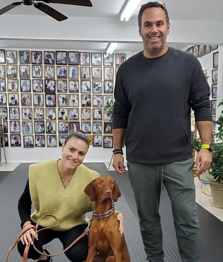 a man and a woman standing next to a dog