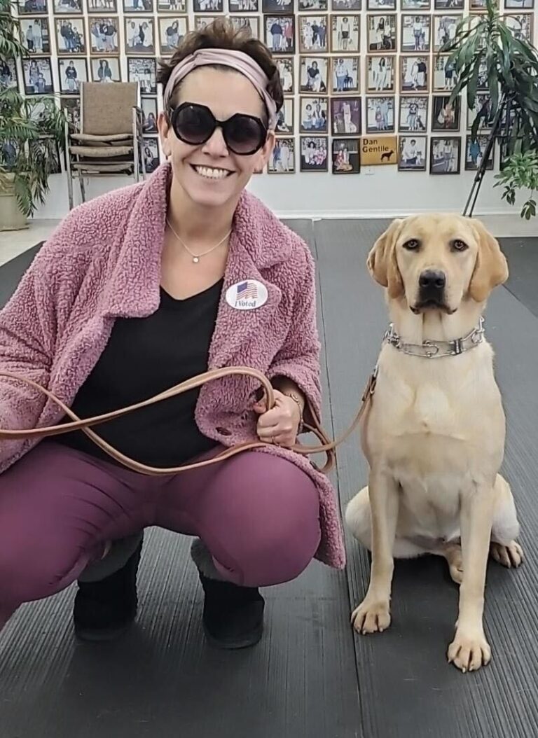 a woman kneeling down next to a dog on a leash