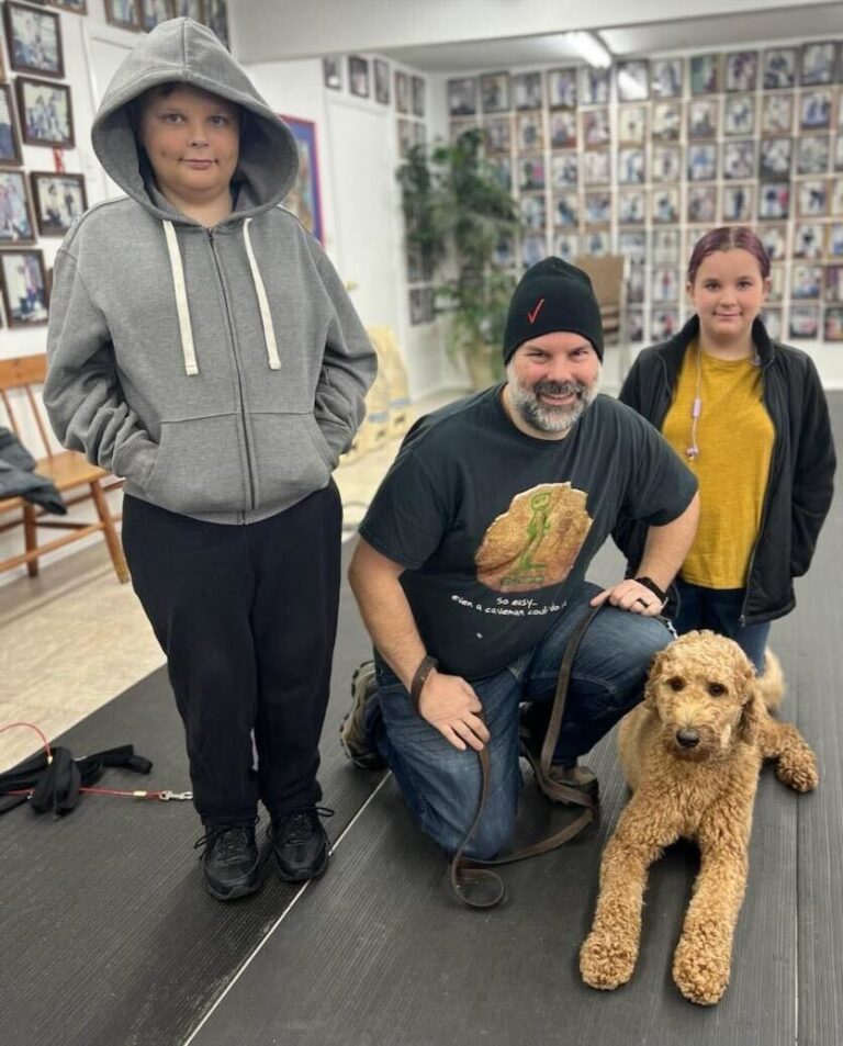 three people and a dog are posing for a picture