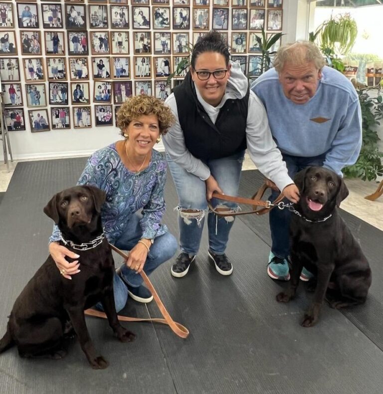 a group of people with two dogs on leashes