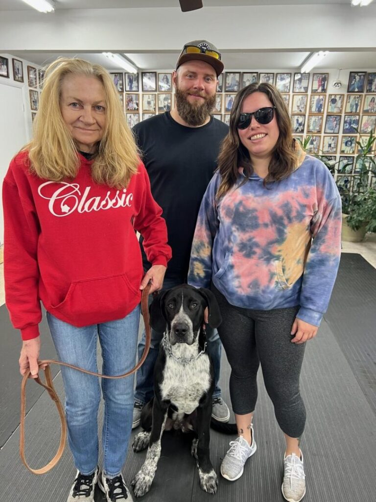 a group of people standing next to a dog