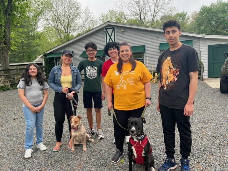 a group of people standing next to a dog
