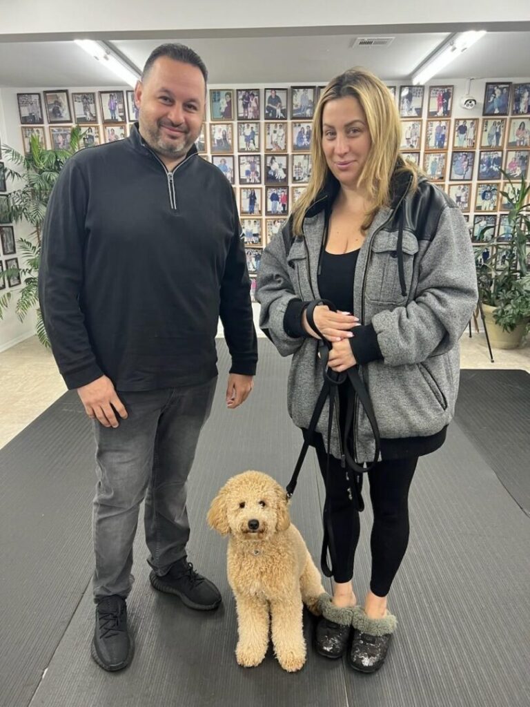 a man and a woman standing next to a dog
