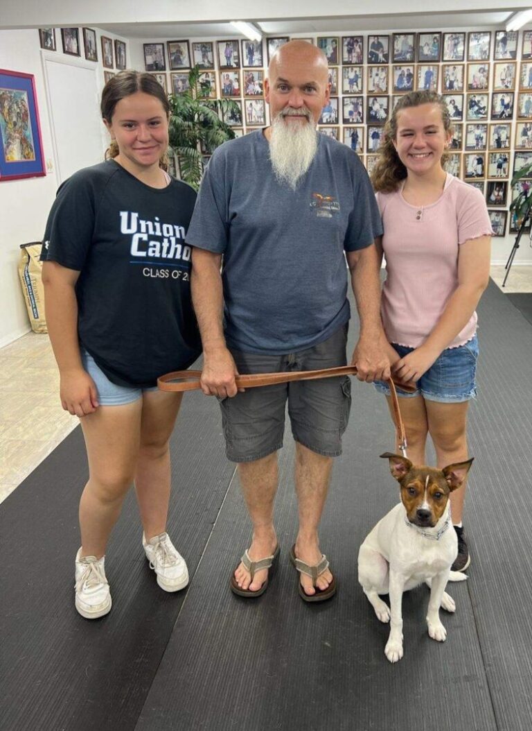 a group of people standing next to a dog