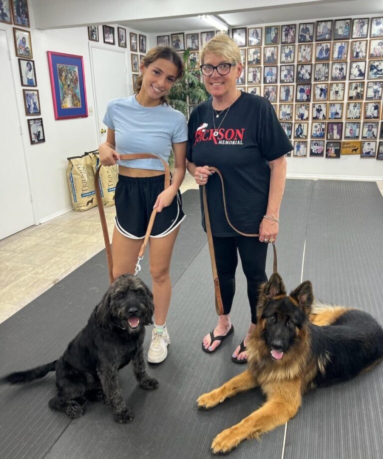 a couple of women standing next to two dogs
