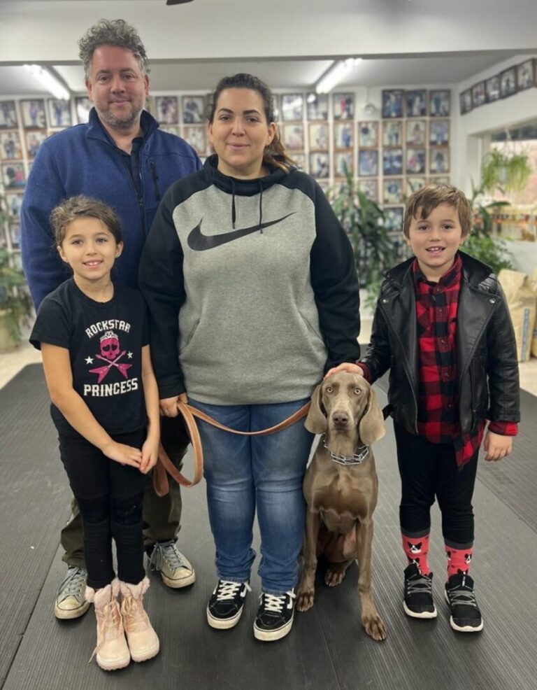 a man, woman and two children with a dog
