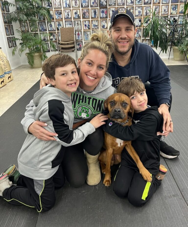 a man, woman and two children pose for a picture with a dog