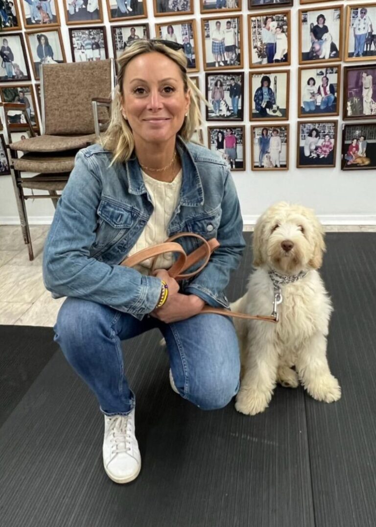a woman kneeling down with a dog on a leash