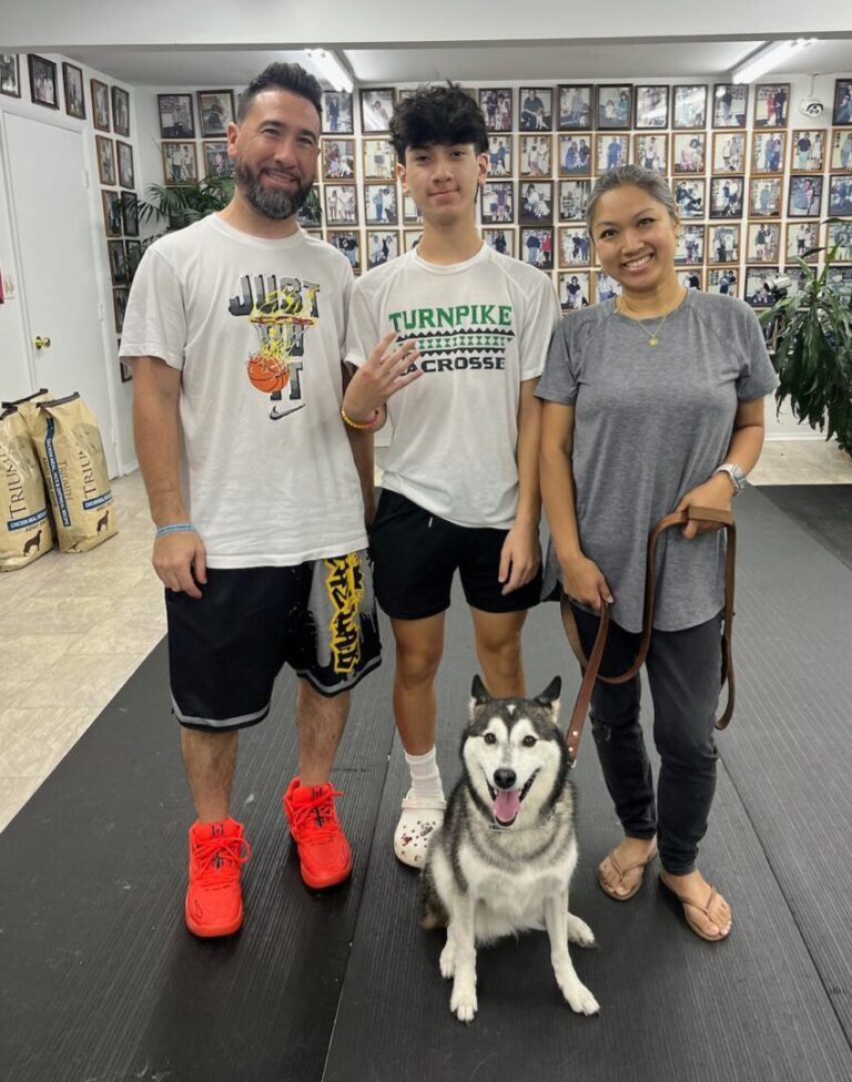 a group of people standing next to a dog on a leash