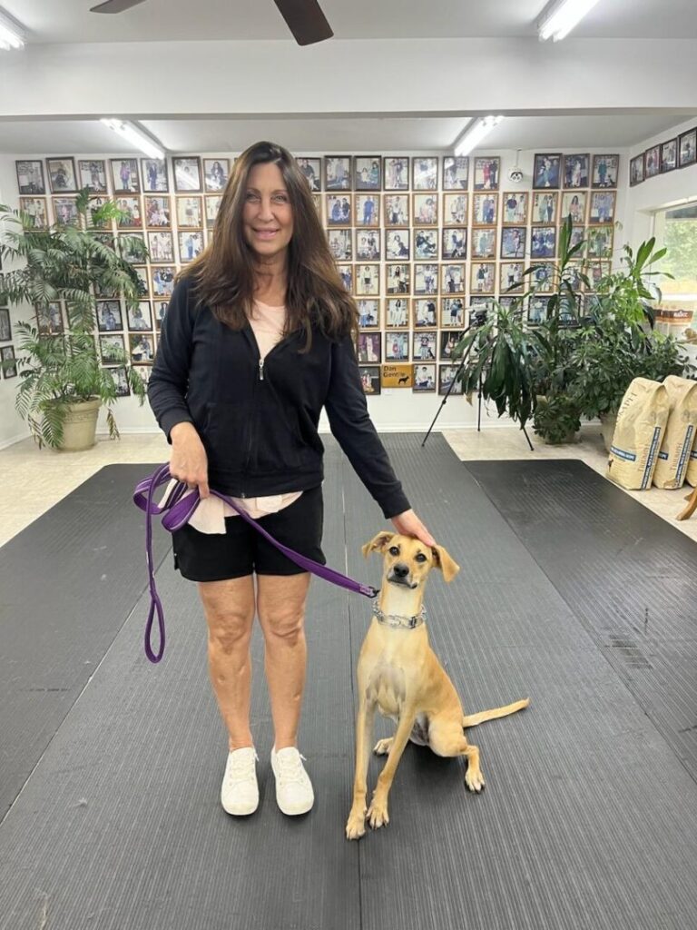 a woman standing on a mat with a dog on a leash
