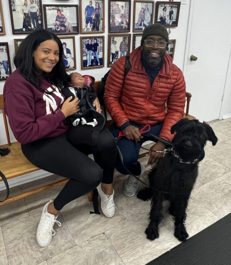 a man and woman sitting on a bench with a dog