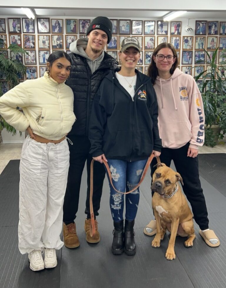 a group of people standing next to a dog