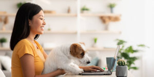 a woman sitting at a table with a dog on her lap