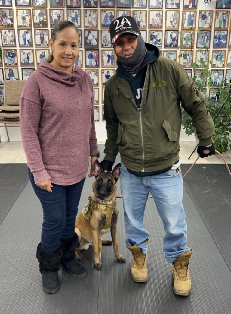 a man and a woman standing next to a dog