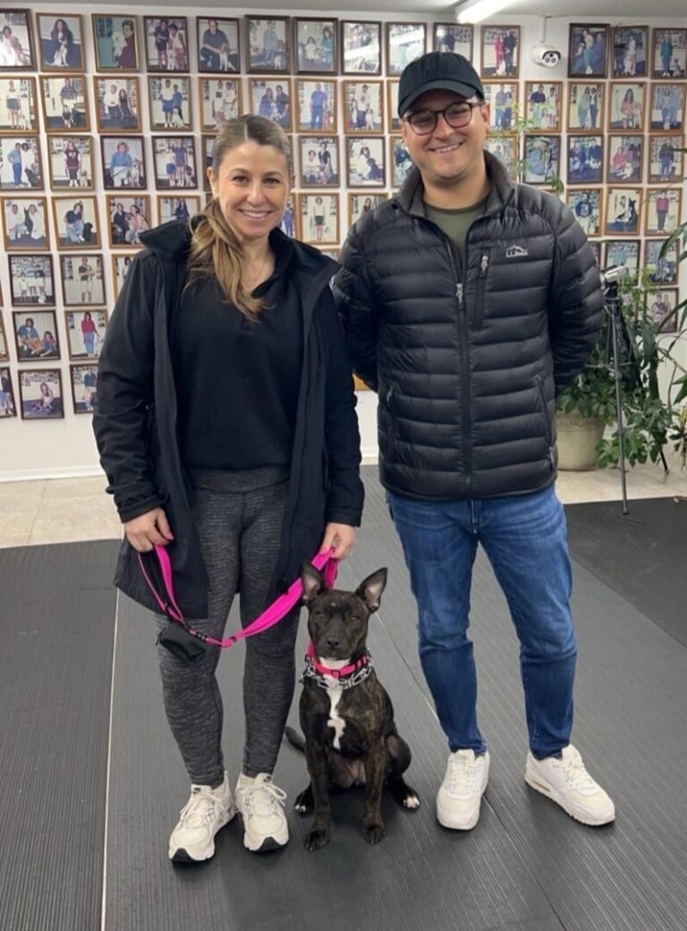 a man and a woman standing next to a dog