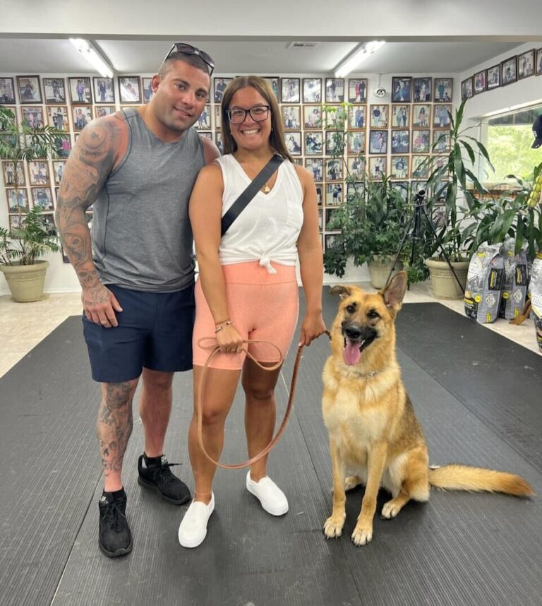 a man and a woman standing next to a dog
