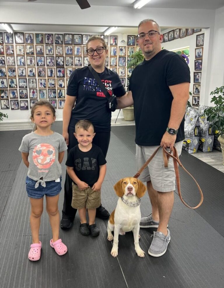 a group of people standing next to a dog on a leash