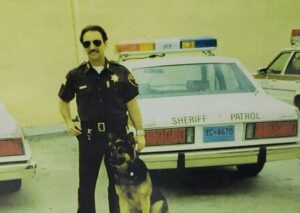 a police officer standing next to a police dog