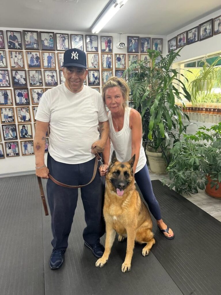 a man and a woman standing next to a dog