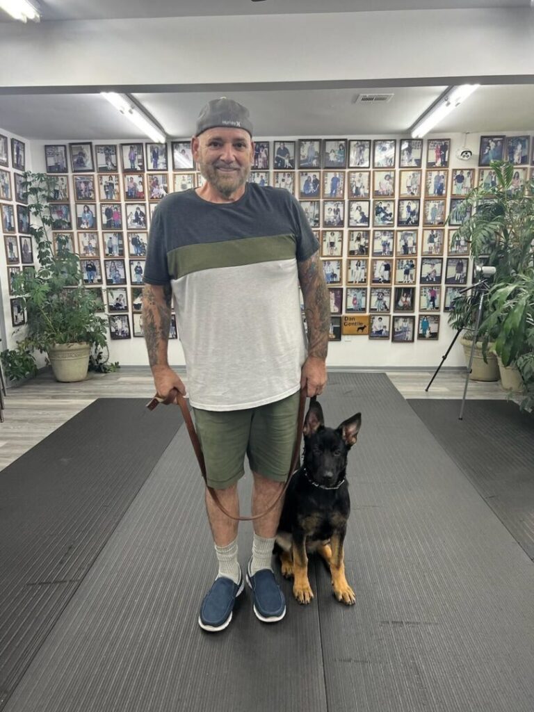 a man standing on a mat with a dog