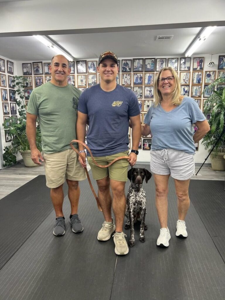 a group of people standing next to a dog