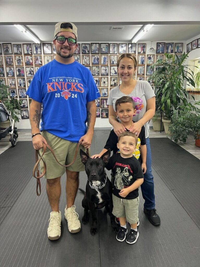 a man, woman, and two children pose for a picture with a dog