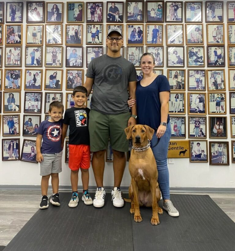 a man, woman, and two children posing for a picture with a dog