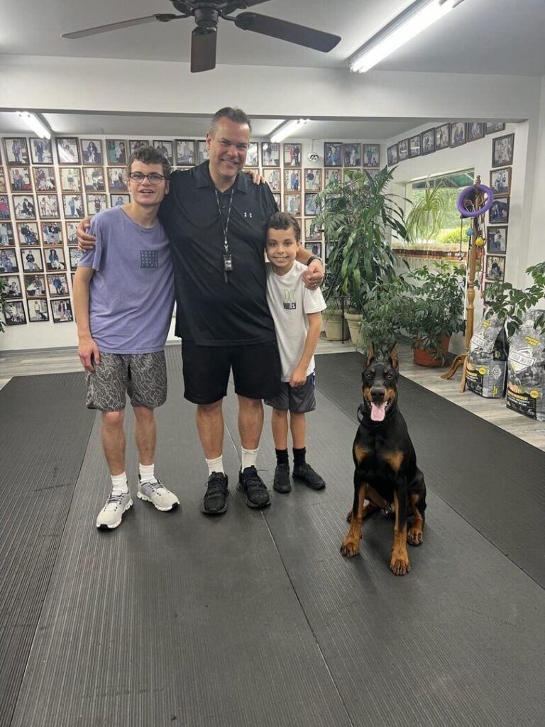 a man and two boys standing next to a dog