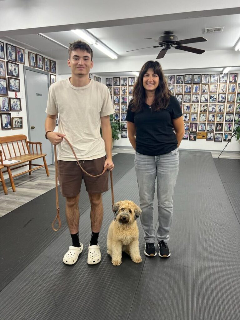 a man and a woman are standing with a dog