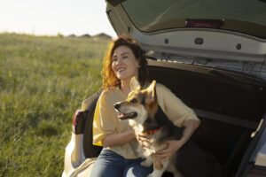 a woman sitting in the back of a car with her dog