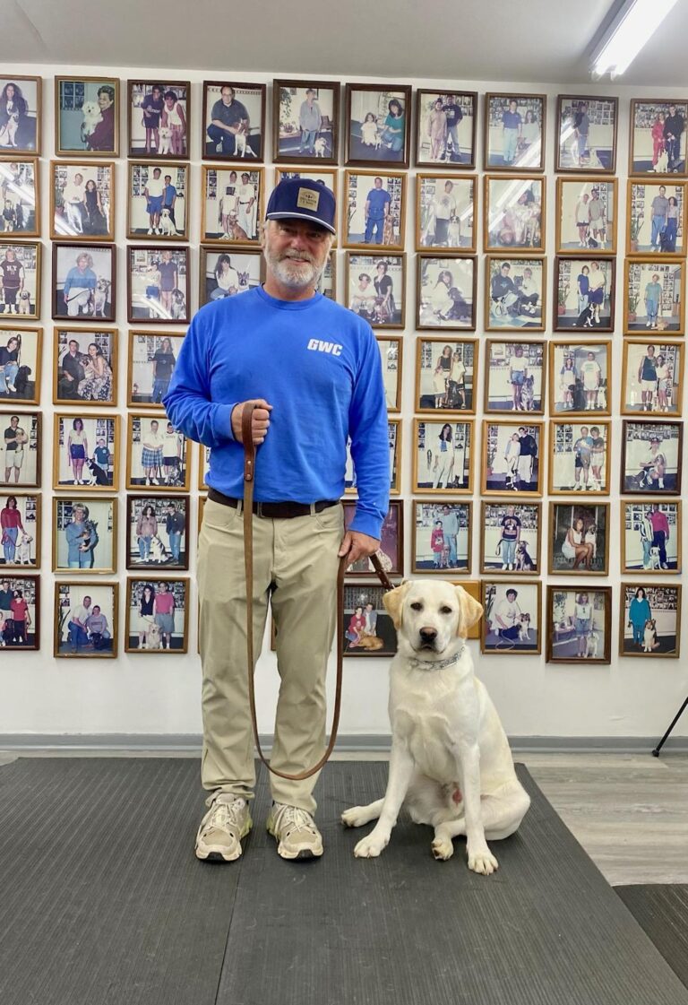 a man standing next to a dog